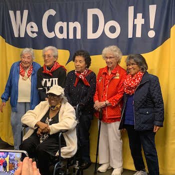Rosies in front of We Can Do It backdrop at Riveter Days